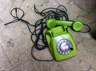 altes grünes Telefon mit Hörer und Wählscheibe
