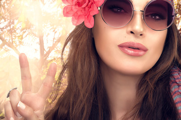 Fototapeta premium Hippie Girl enjoying Nature Showing Peace Hand Sign