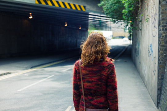 Woman walking on the street near an underpass
