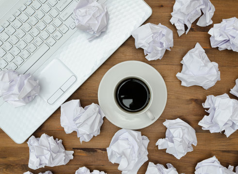 business concept. Laptop, cup of coffee paper sheets and crumple