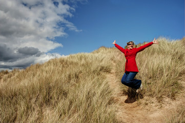 Woman jumping for joy by the beach