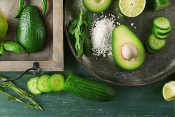 Sliced avocado, cucumber/ pepper and lemon lime on wooden background
