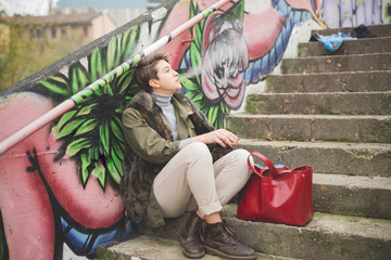 Young woman smoking cigarette while sitting on steps
