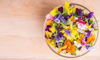 Mix edible flower salad in a glass bowl