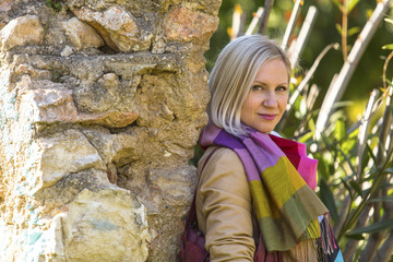 Young woman near a stone wall in a city Park.