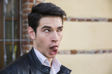 Young man outdoor doing silly face and stupid expression