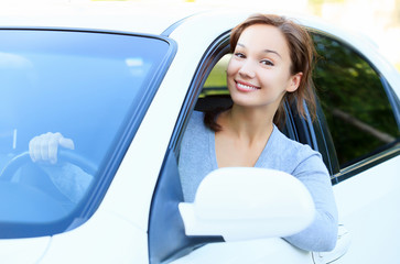 Pretty girl in a car smiling to you