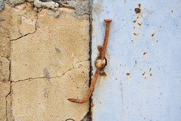 Very old metal door lock with a rusty nail