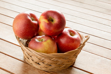 Apples in a basket on wooden background