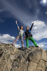 Group of two happy female climbers  celebrates victory