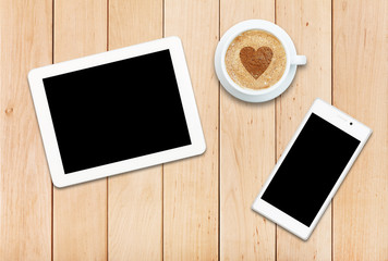 Two gadgets and coffee on a wooden table