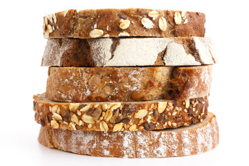 Mixed slices of health breads stacked. White surface.