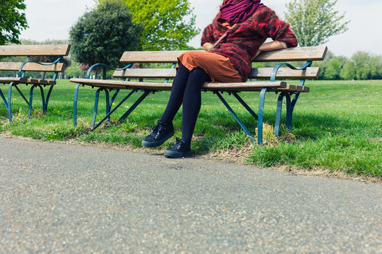 Woman resting on bench in park