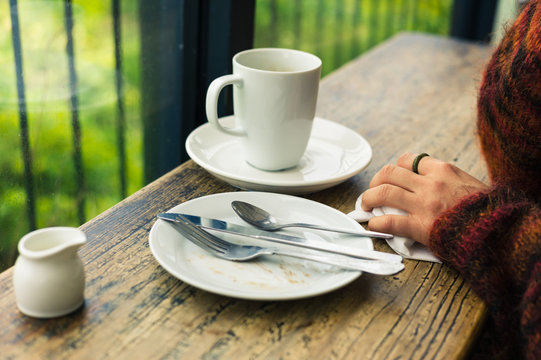 Woman with empty plates and mug
