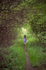 Fototapeta na wymiar Little lonel girl in green nature gateway