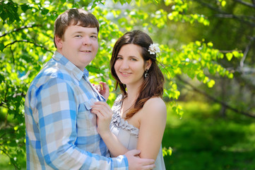 Beautiful man and woman walking in the flowering spring park