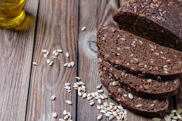 Traditional dark bread with sunflower seeds on a wooden table.