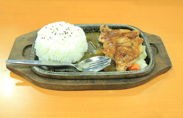 Teriyaki chicken rice in hot frying pan.