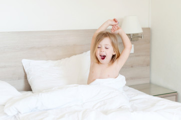 little girl yawning in bed