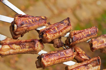 Three skewers with grilled ribs on nature