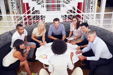 Group of work colleagues having meeting in an office lobby
