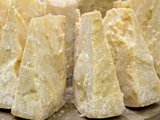 thick slices of Italian Parmesan cheese on  wooden cutting board