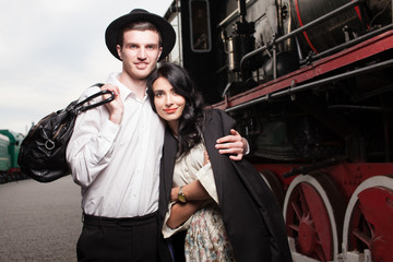 happy couple of traveler at railway station