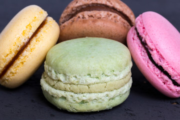 Bunte Macarons auf schwarzem Holz