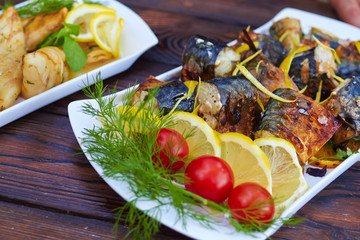 fish roasted on the fire with fresh tomatoes, lemon and dill