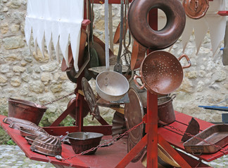 collander and other old copper objects in cart for sale at flea