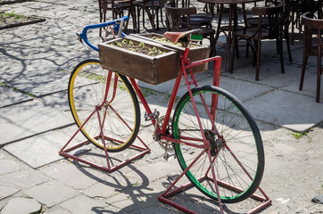 Fototapeta na wymiar Old red vintage bicycle with flowers in the flower bed frame