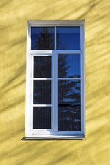 Old window on yellow wall