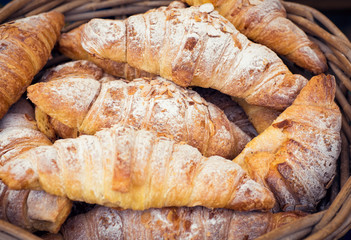 Homemade Almond Croissants in basket, food market display