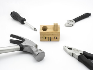 Set of tools and wood house toy on white background
