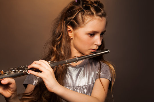 Close-up view of girl playing on silver flute