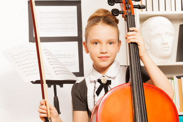 Portrait of girl holding fiddle-bow to play cello © Sergey Novikov