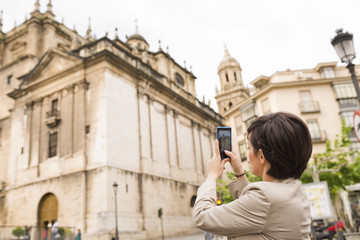 Fototapeta na wymiar City photo. Woman taking cathedral picture image.