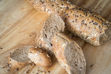baguette rye bread with various seeds on a wooden board