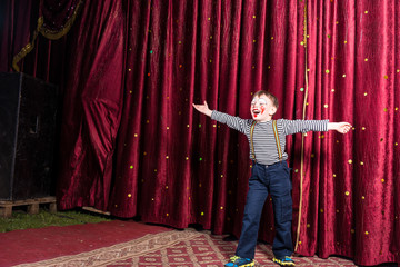 Laughing confident little boy on stage