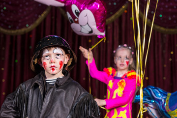 Boy Clown on Stage with Girl Holding Balloons
