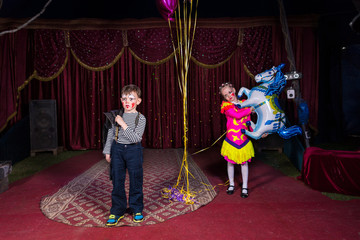Boy Clown on Stage with Girl Holding Horse Balloon