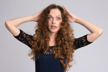 Surprised woman with long curly hair