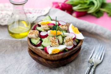 Salad with radish, cucumber, eggs and bread croutons