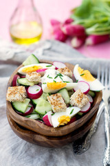 Salad with radish, cucumber, eggs and bread croutons