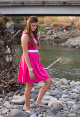 Young audlt portrait in pink dress outdoors.