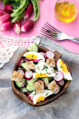 Salad with radish, cucumber, eggs and bread croutons
