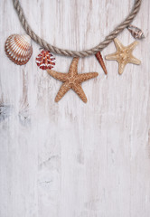Fototapeta na wymiar Seashells and rope on the old shabby wood