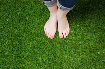 Woman legs in jeans standing  on grass