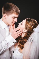 Groom kissing bride on wedding. Black background.