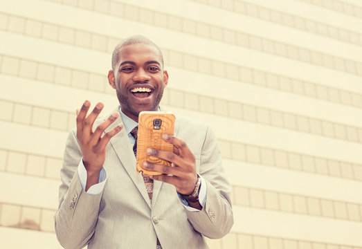Excited man looking at his smart phone reading news message